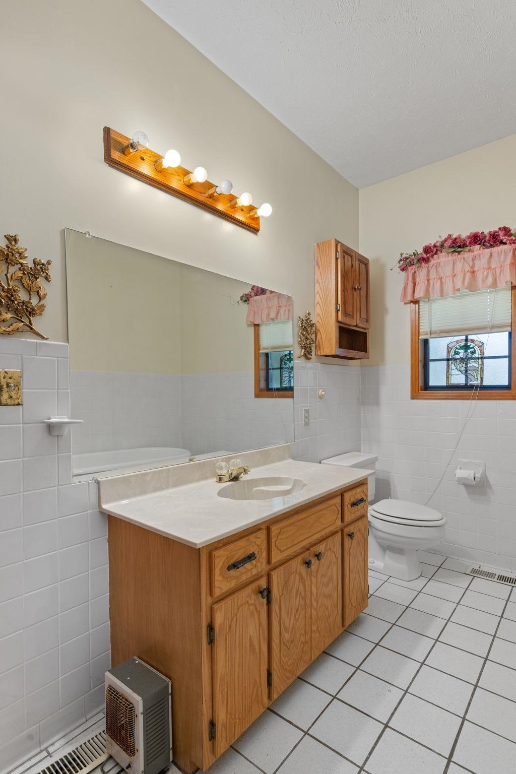 165 Highway 201 Reagan, TN 38368 - Photo 36 of 40 Bathroom featuring tile walls, a wainscoted wall, light tile patterned flooring, and vanity