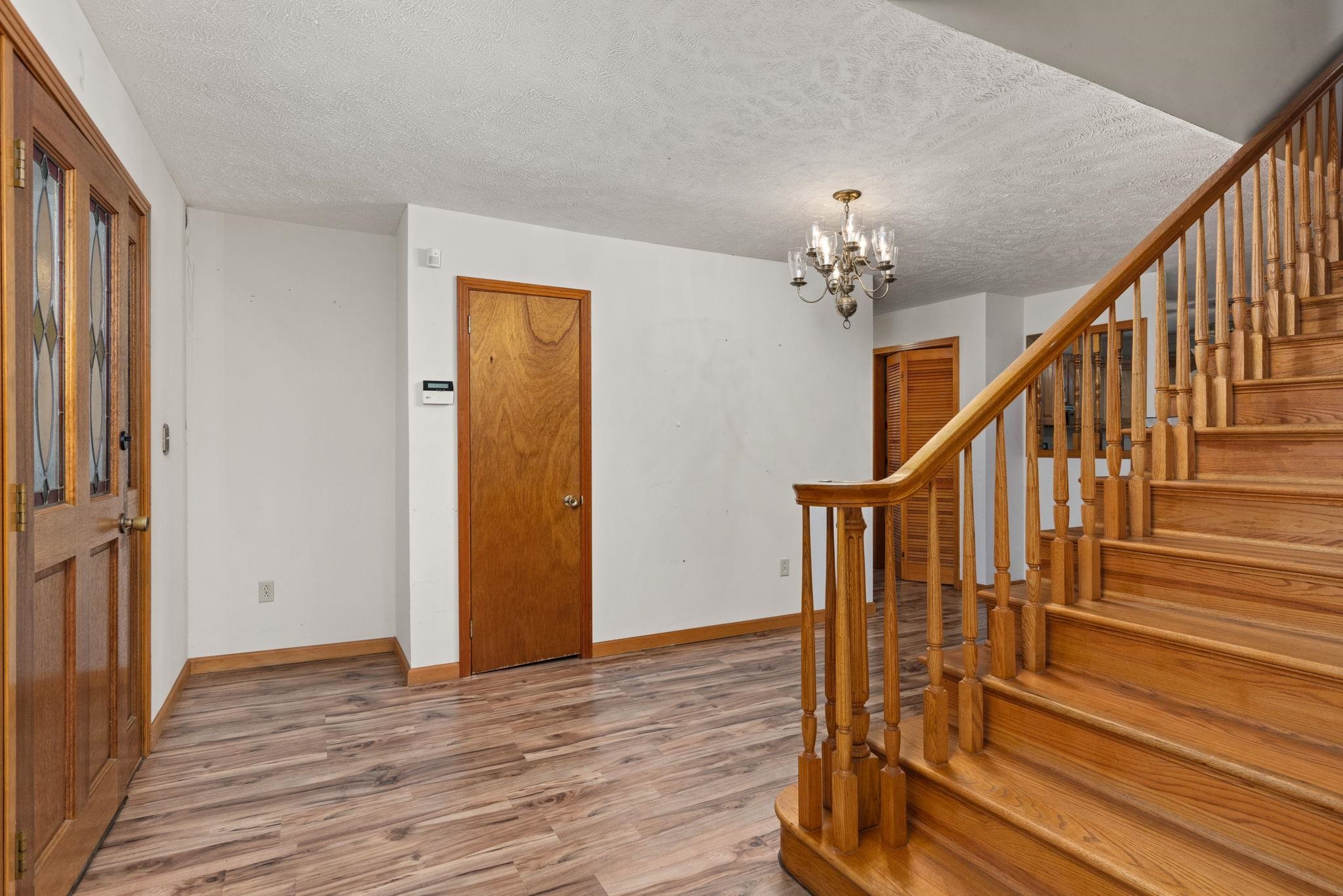 165 Highway 201 Reagan, TN 38368 - Photo 37 of 40 Foyer entrance with wood finished floors, a textured ceiling, a chandelier, and stairs