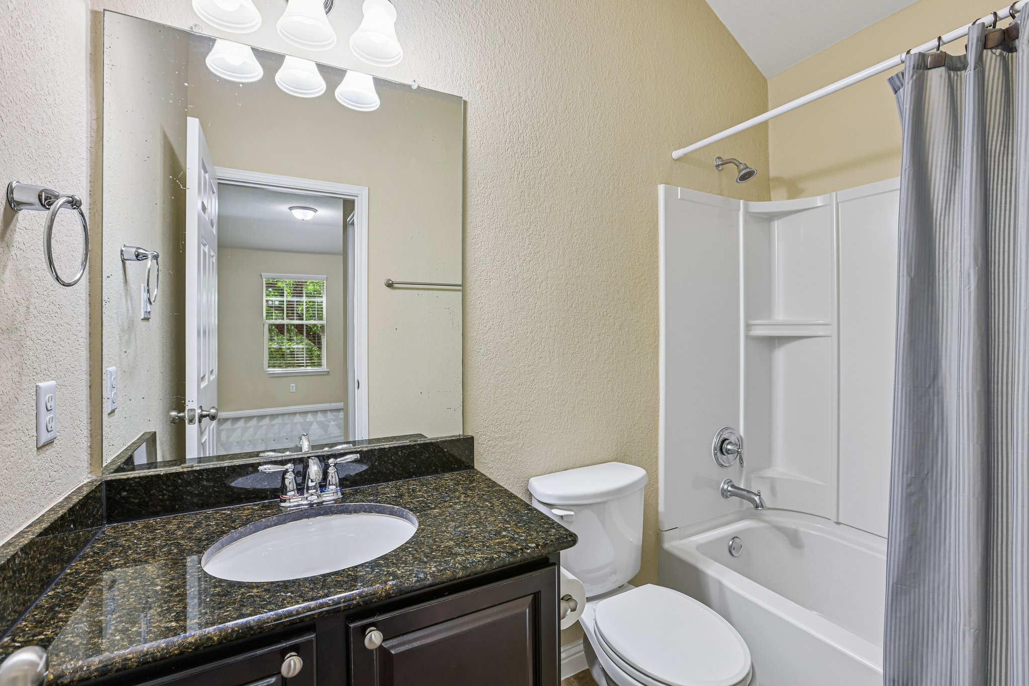 1924 Granite Springs Road Leander, TX 78641 - Photo 26 of 36 Bedroom #2's connected bathroom. Well-lit full bath features a single vanity with granite counters and a shower-tub combination.