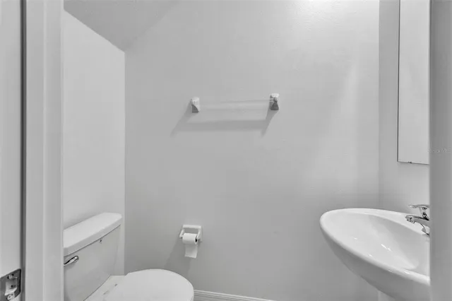 a bathroom with a sink mirror and toilet