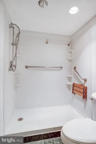 a bathroom with a shower a toilet and a shower
