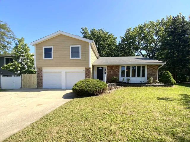 a front view of a house with yard and garage