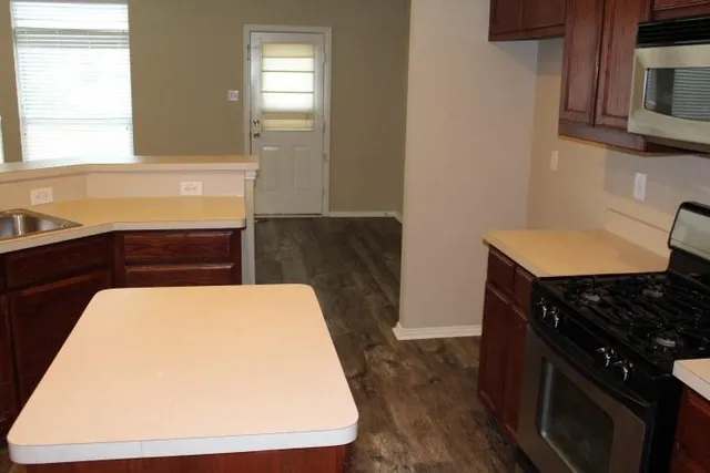 a stove top oven sitting inside of a kitchen