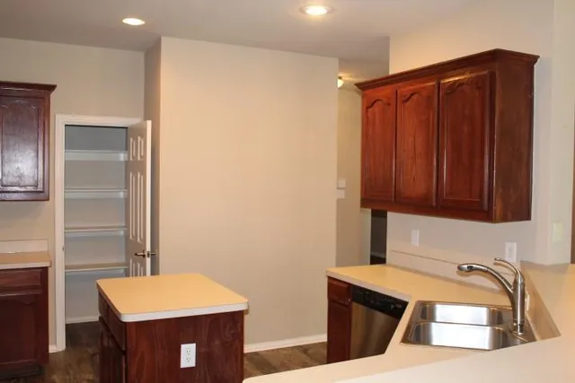 a kitchen with stainless steel appliances granite countertop a refrigerator and a stove top oven