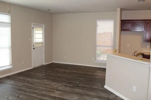 a view of a big room with wooden floor and windows