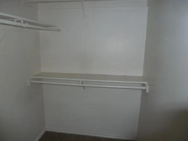 an empty room with a window and a ceiling fan