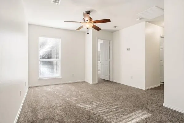 an empty room with windows and fan