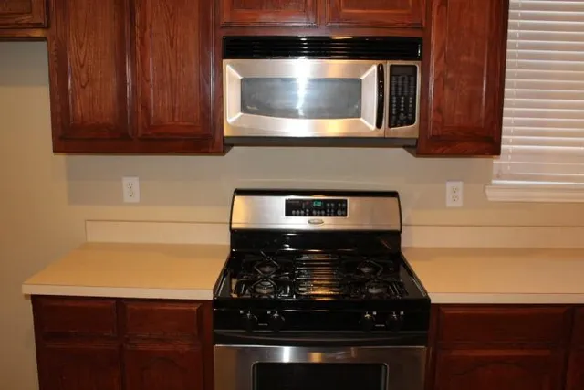 a kitchen with stainless steel appliances granite countertop a sink stove and microwave
