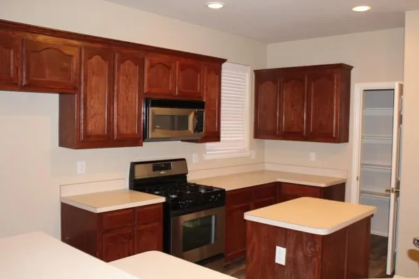 a kitchen with stainless steel appliances granite countertop a stove a sink and a microwave