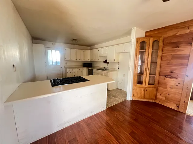 a large white kitchen with wooden floors and white walls