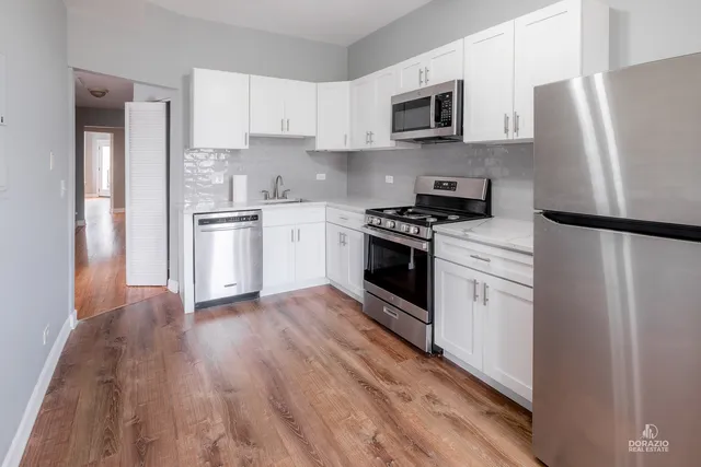 a kitchen with stainless steel appliances a refrigerator stove and microwave