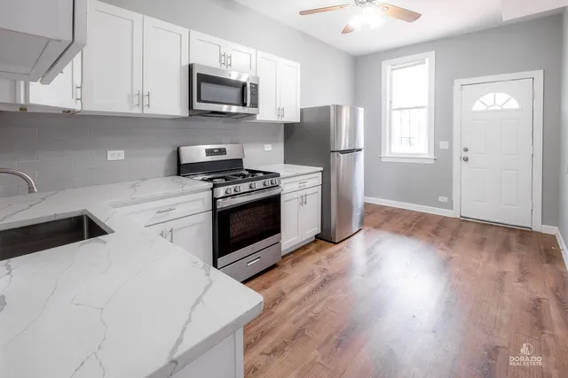 a kitchen with stainless steel appliances granite countertop a stove a refrigerator and a sink