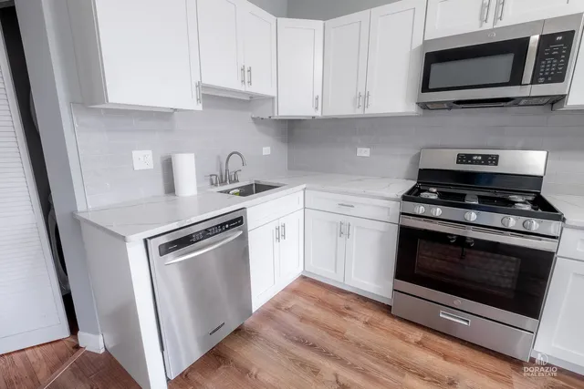 a kitchen with stainless steel appliances granite countertop a stove a microwave and a sink