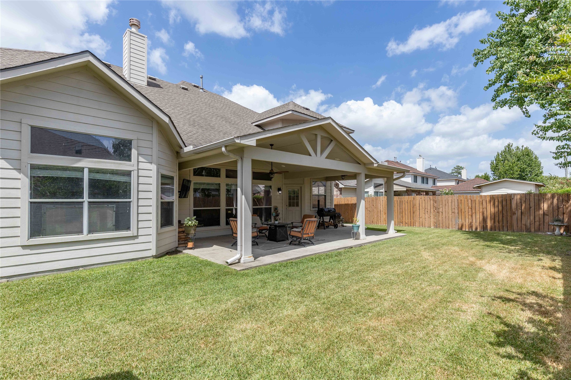 24506 Fort Path Drive Spring, TX 77373 - Photo 40 of 46 Spacious backyard with a covered patio perfect for outdoor relaxation, featuring a well-maintained lawn and privacy fence.