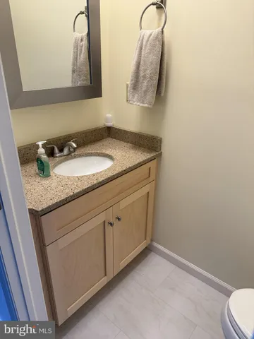 a bathroom with a granite countertop sink and a mirror