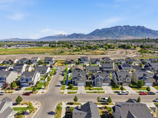 3244 West 1670th Street North Provo, UT 84601 - Photo 55 of 56 Residential neighborhood featuring mature street trees, manicured lawns, and a mountainous backdrop
