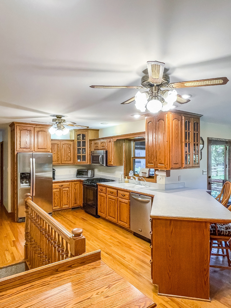 42W420 Kedeka Road Sugar Grove, IL 60554 - Photo 6 of 32 a large kitchen with kitchen island a large counter space appliances and cabinets