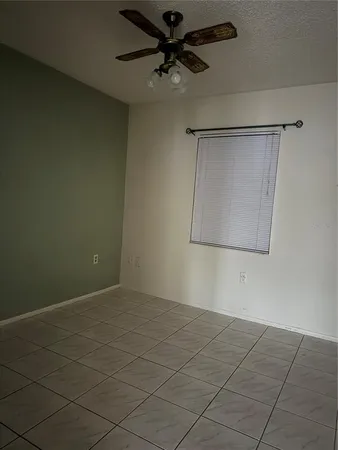 an empty room with a ceiling fan and a window