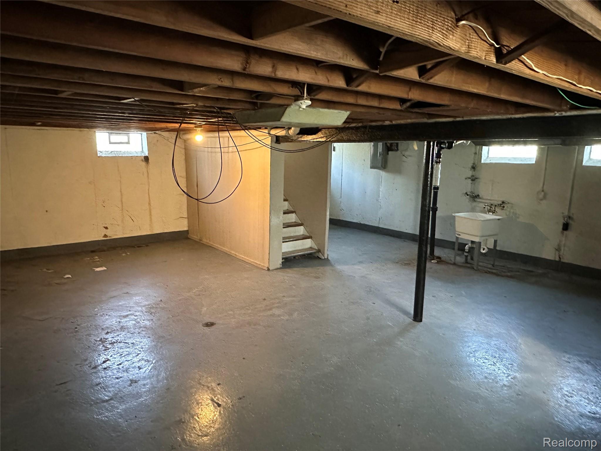27366 Freda Street Inkster, MI 48141 - Photo 14 of 14 Painted concrete flooring, exposed ceiling joists, utility sink with wall-mounted plumbing, multiple casement windows