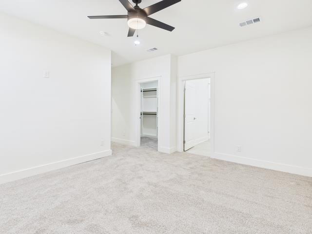 511 Richardson Street Athens, TX 75751 - Photo 20 of 40 Unfurnished bedroom featuring a walk in closet, light colored carpet, and a ceiling fan