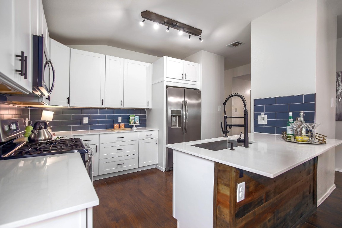 a kitchen with sink stove and cabinets