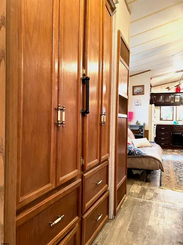 a bedroom with a bed a dresser and windows