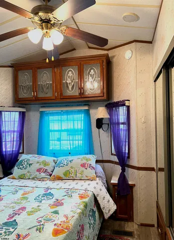 a bedroom with a bed a dresser and windows