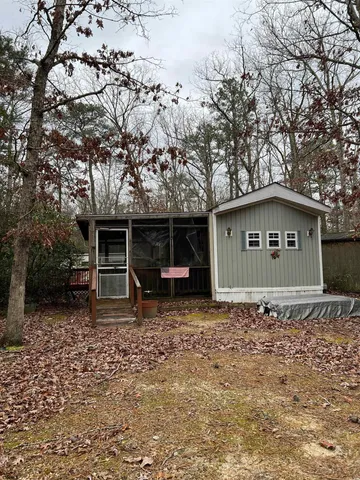 a wooden house with trees in the background