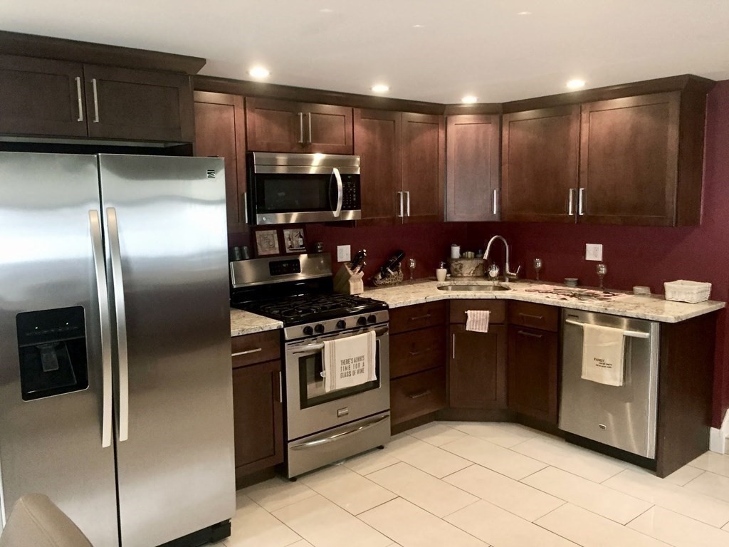 26 Chamberlain Road Chelmsford, MA 01824 - Photo 23 of 35 a kitchen with stainless steel appliances granite countertop a sink a stove a refrigerator and cabinets