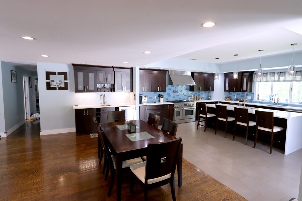 26 Chamberlain Road Chelmsford, MA 01824 - Photo 6 of 35 a kitchen with stainless steel appliances kitchen island granite countertop a refrigerator a stove a sink a dining table and chairs