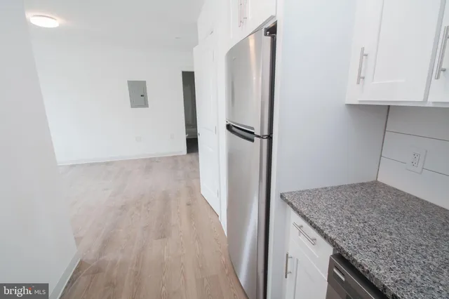 a kitchen with granite countertop a refrigerator and a counter space