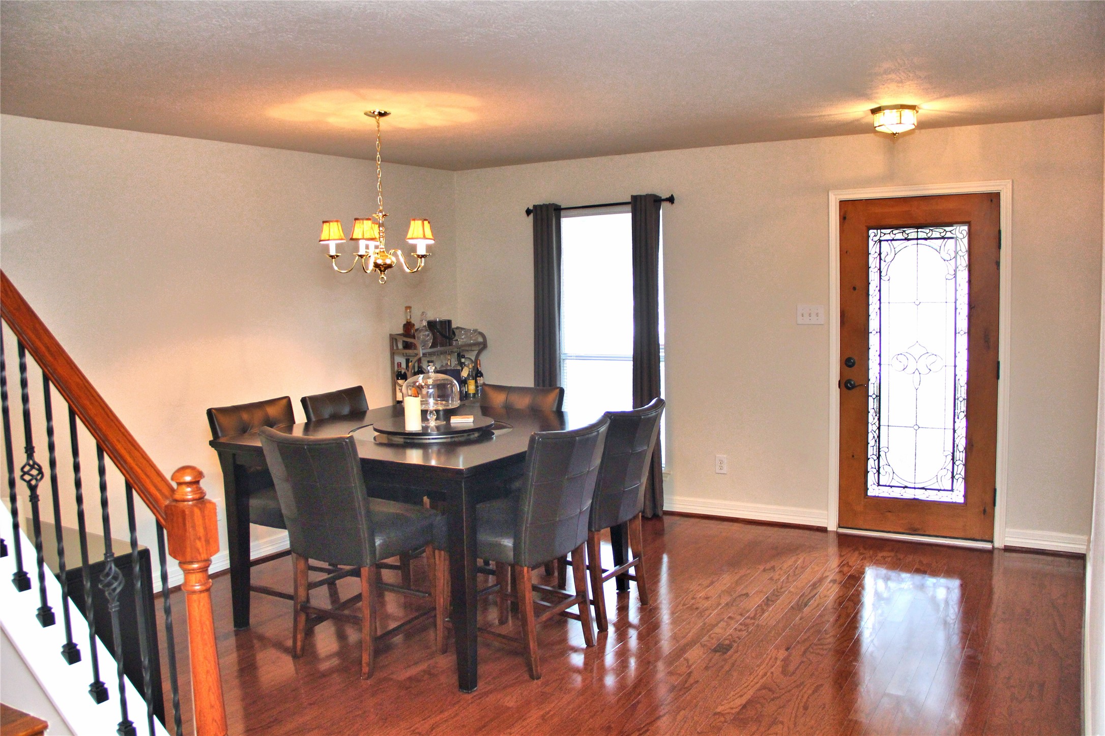 10234 Turrett Point Lane Houston, TX 77064 - Photo 2 of 17 a dining room with furniture wooden floor a rug a potted plant and a chandelier