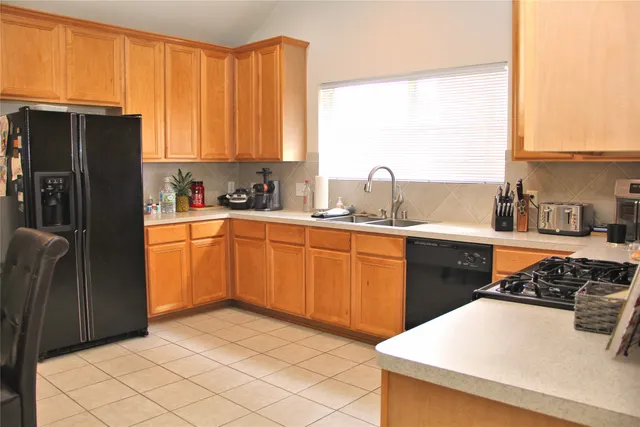 a kitchen with stainless steel appliances a sink a stove a refrigerator a counter top space and cabinets