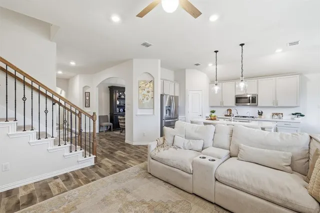 a kitchen with a sink a stove cabinets and living room view