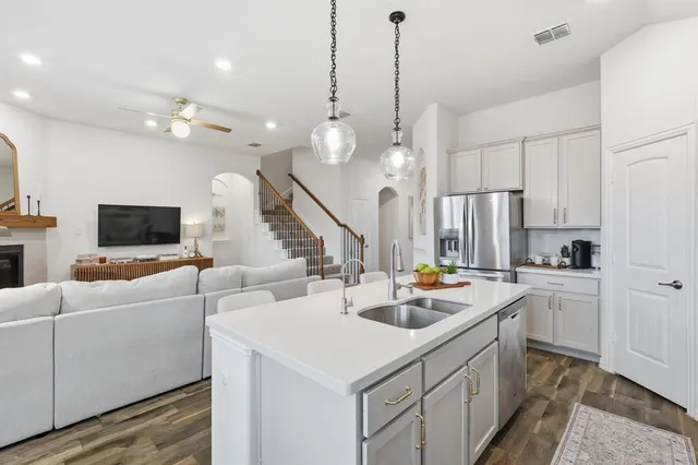 a kitchen that has a sink a microwave and cabinets