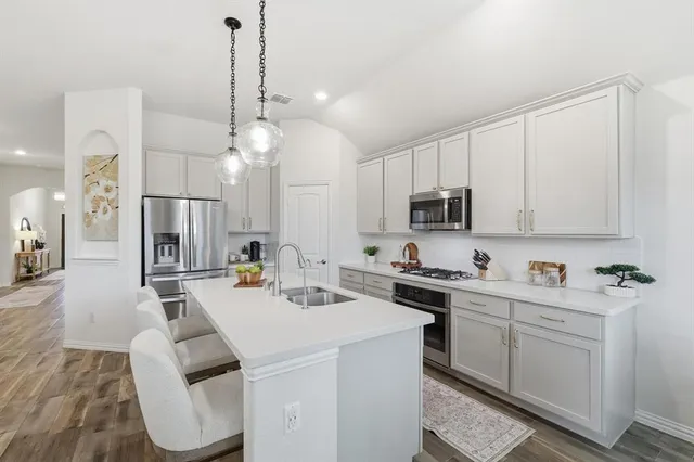 a kitchen with sink refrigerator and dining table