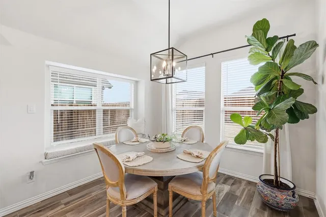 a dining room with furniture a chandelier and wooden floor