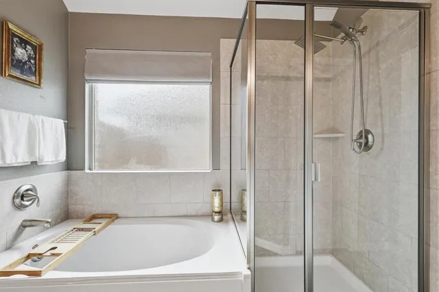 a en suite spacious bathroom with a tub sink and mirror