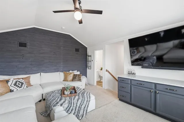 a backyard of a house with couches plants and wooden fence