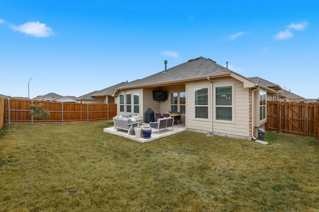 a view of a house with a backyard and sitting area