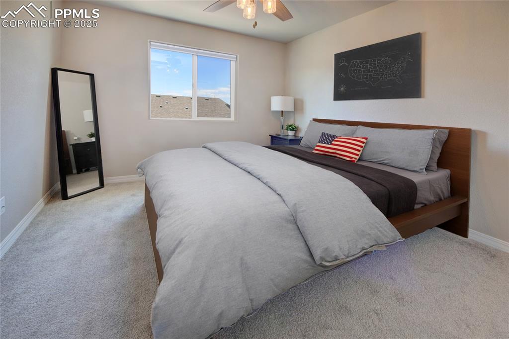 6069 Inman View Colorado Springs, CO 80924 - Photo 26 of 38 a bedroom with a bed and a chandelier