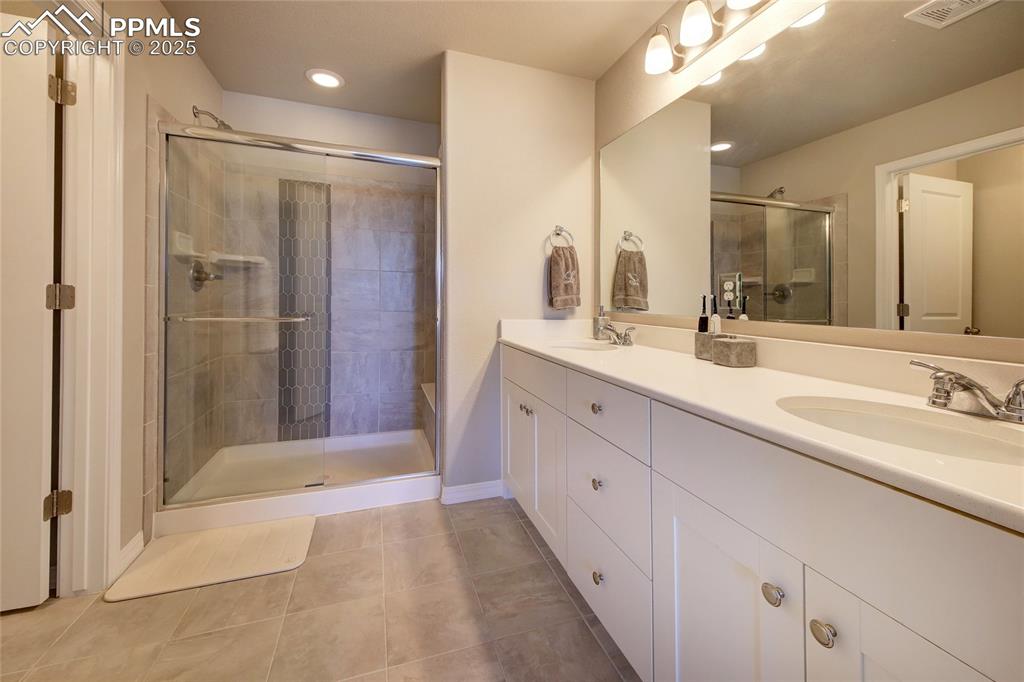 6069 Inman View Colorado Springs, CO 80924 - Photo 27 of 38 a bathroom with a double vanity sink mirror and shower