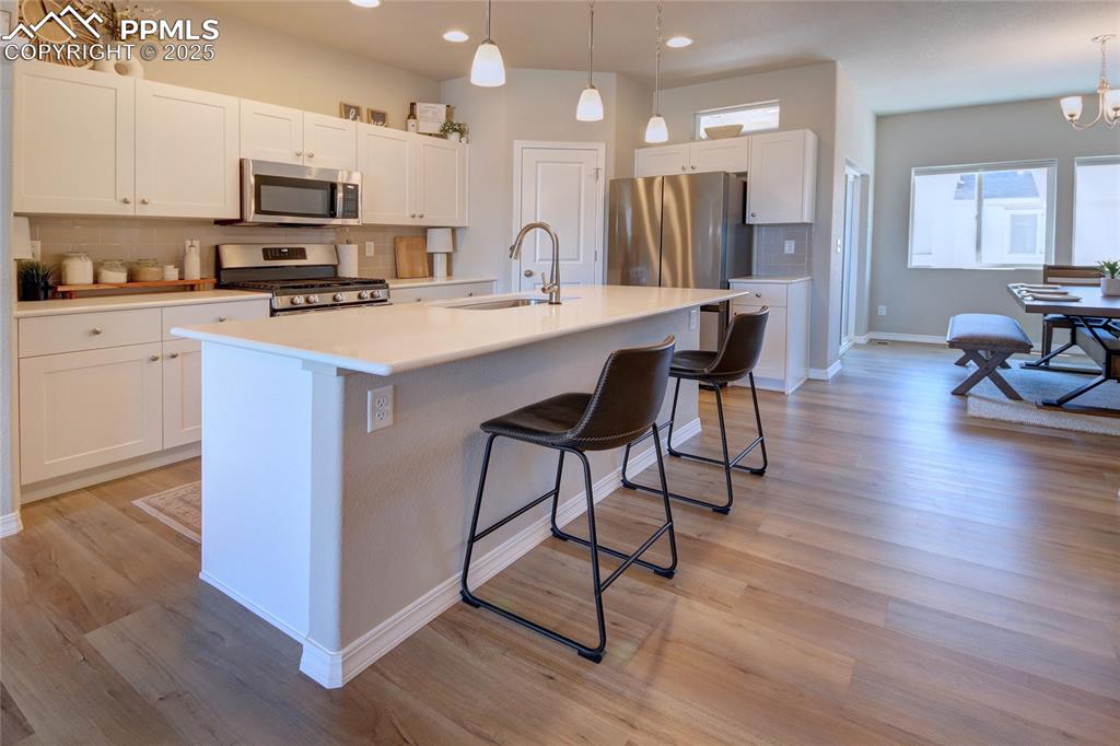 6069 Inman View Colorado Springs, CO 80924 - Photo 4 of 38 a kitchen with stainless steel appliances kitchen island granite countertop a stove a sink a microwave and a refrigerator