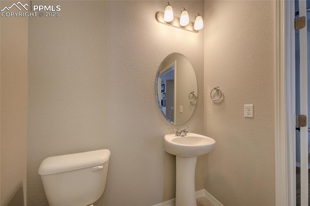 6069 Inman View Colorado Springs, CO 80924 - Photo 5 of 38 a bathroom with a toilet sink and mirror