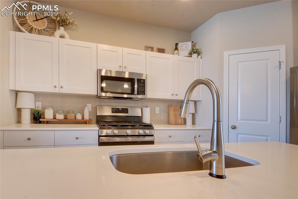6069 Inman View Colorado Springs, CO 80924 - Photo 10 of 38 a kitchen with stainless steel appliances granite countertop a sink a stove a microwave and cabinets