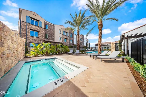 a view of a swimming pool with a lounge chair and palm trees