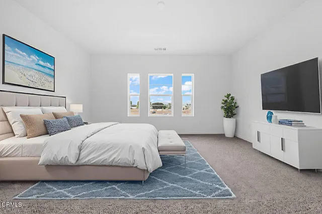 a spacious bedroom with a large bed and a flat screen television