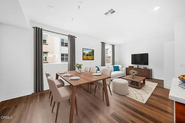 a living room with furniture a flat screen tv and a window