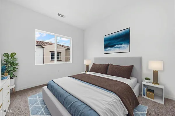 a bedroom with a bed and a painting on the wall