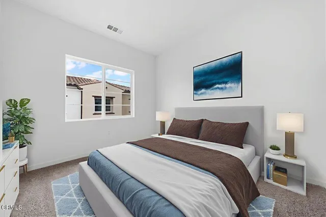 a bedroom with a bed and a painting on the wall